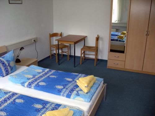 um quarto com uma cama, uma mesa e cadeiras em Pension Savo em Chemnitz