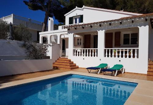 a villa with a swimming pool in front of a house at Casa Toro Vista in Son Parc