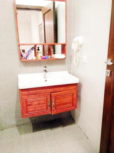 a bathroom with a sink and a mirror at Jade Dragon Hotel DHA Lahore in Lahore