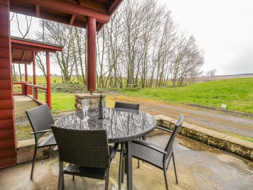 a table and chairs on the porch of a cabin at Ingram in Morpeth