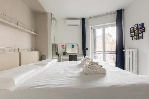 BnButler - Largo Promessi Sposi - Moderno e Confortevole في ميلانو: سرير أبيض كبير في غرفة مع نافذة