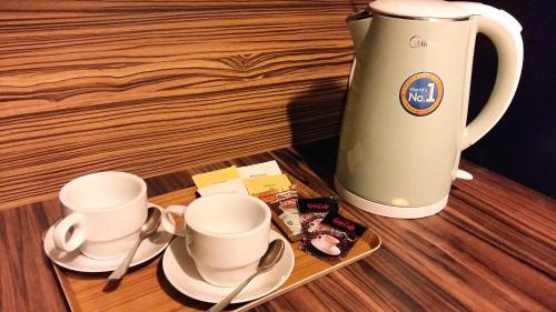 a table with two cups and a tea kettle at Cuti de Gold Coast Morib in Banting