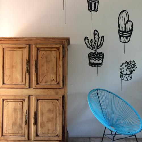 a room with a wall with cactus and a blue chair at Oustal du pic saint loup in Saint-Jean-de-Cuculles