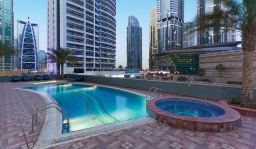 a swimming pool in a city with tall buildings at Luxury apartment on the metro facing Dubai Marina in Dubai