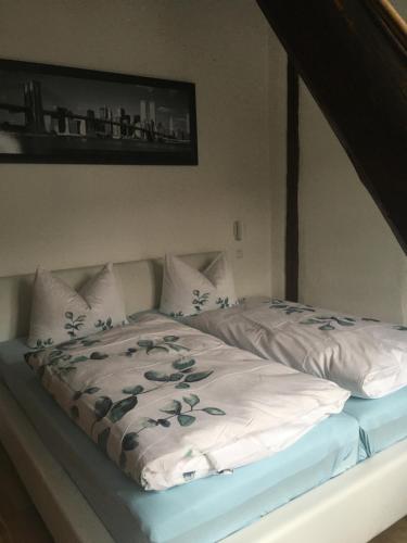 a bed with a white comforter with flowers on it at Ferienhaus Alte Scheune in Pommern
