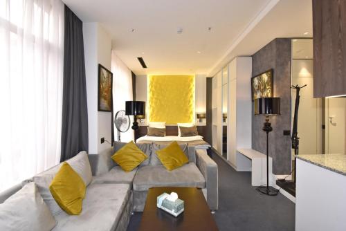 a living room with a couch and a bed at Avenue ApartHotel in Yerevan