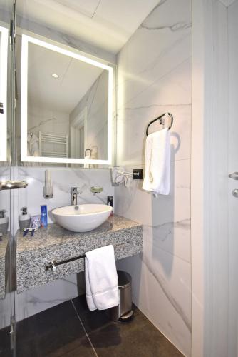 a bathroom with a sink and a mirror at Avenue ApartHotel in Yerevan