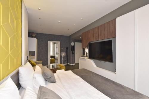 a bedroom with a large bed with a television on the wall at Avenue ApartHotel in Yerevan
