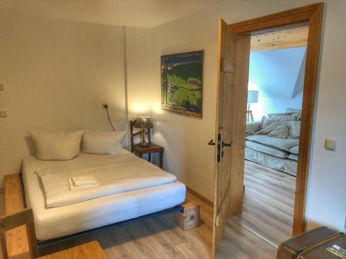 a small room with a bed and a door to a bedroom at Alpina Lodge Hotel Oberwiesenthal in Kurort Oberwiesenthal