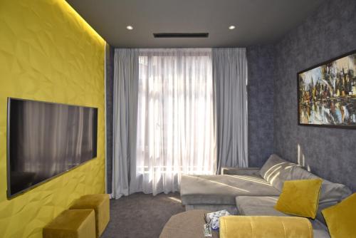 a living room with a couch and a large window at Avenue ApartHotel in Yerevan