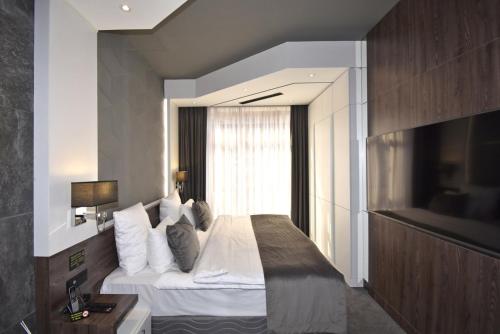 a bedroom with a large bed with a window at Avenue ApartHotel in Yerevan