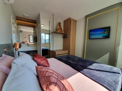 une chambre avec un lit avec des oreillers dessus dans l'établissement Lindo apto tudo novinho, prédio frente mar, à Balneário Camboriú