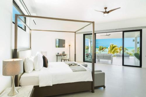 a bedroom with a bed and a view of the ocean at Paradiso Del Mar, Turtle Tail, TCI in Turtle Cove