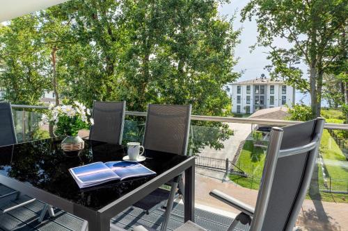 a black table and chairs on a balcony with a view at Apartment "Haffblick" - Haffresidenz in Garz