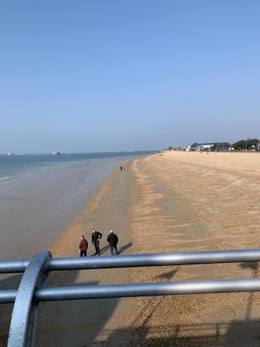 um grupo de pessoas caminhando na praia em The Wellington Restaurant and Bar em Portsmouth