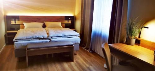 niewielka sypialnia z łóżkiem i biurkiem w obiekcie Atelier Hotel Essen-City w Essen