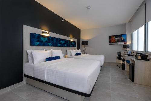 a bedroom with two beds and a desk with a computer at DoubleTree by Hilton Guayaquil in Guayaquil