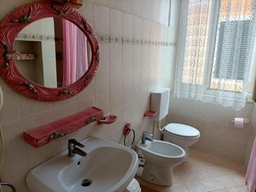 a bathroom with a sink and a toilet and a mirror at La Terrazza nel cuore di Capoliveri in Capoliveri