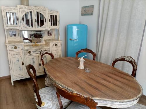 a dining room with a table and a blue refrigerator at La Terrazza nel cuore di Capoliveri in Capoliveri