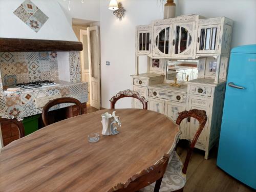 a kitchen with a wooden table and a refrigerator at La Terrazza nel cuore di Capoliveri in Capoliveri