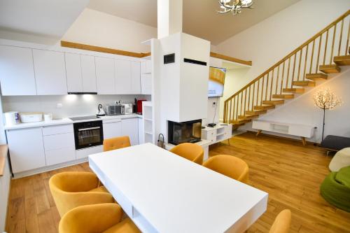 a kitchen and dining room with a white table and chairs at Mountain Top Deluxe + free garage parking in Bjelašnica