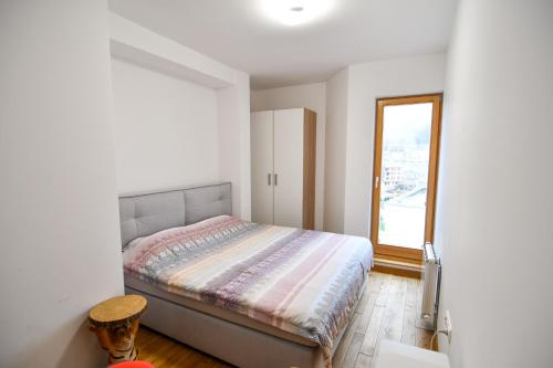 a small bedroom with a bed and a window at Mountain Top Deluxe + free garage parking in Bjelašnica