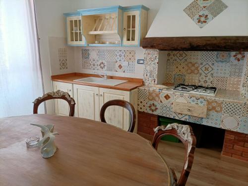 a kitchen with a wooden table with chairs and a sink at La Terrazza nel cuore di Capoliveri in Capoliveri