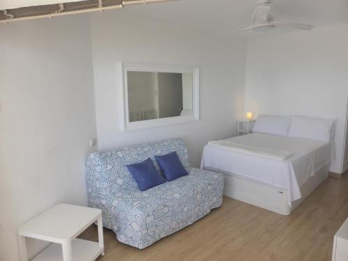 a small bedroom with a bed and a chair at Estudio Nefeli in Benalmádena