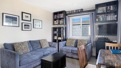 a living room with a couch and a tv at Montauk Oceanside Suites in Montauk