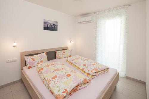 a bedroom with a bed with pink and yellow sheets at Kiefer-Apartments in Rust