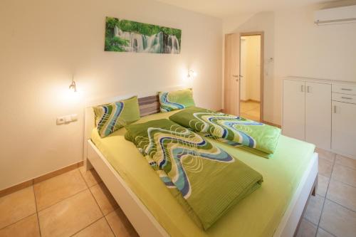 ルストにあるKiefer-Apartmentsのベッドルーム1室(緑のシーツが備わるベッド1台付)