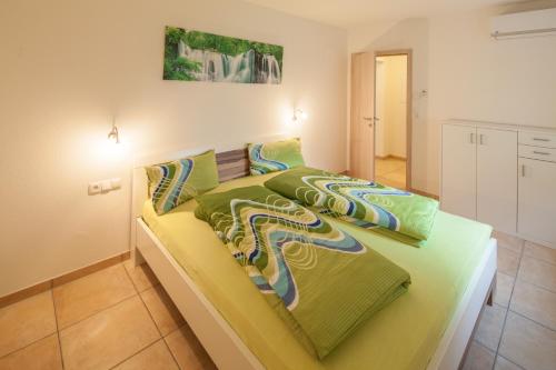 a bedroom with a bed with green sheets at Kiefer-Apartments in Rust