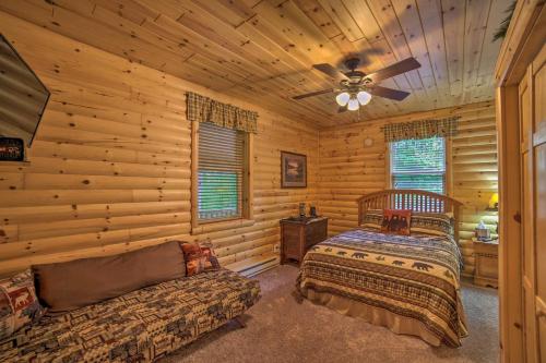 a log cabin bedroom with two beds and a couch at Updated Manistique Log Cabin, Yard and Fire Pit in Manistique