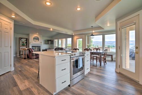 a kitchen with white cabinets and a dining room with a table at Manson Villa with Hot Tub about 1 Mi to Wineries! in Manson