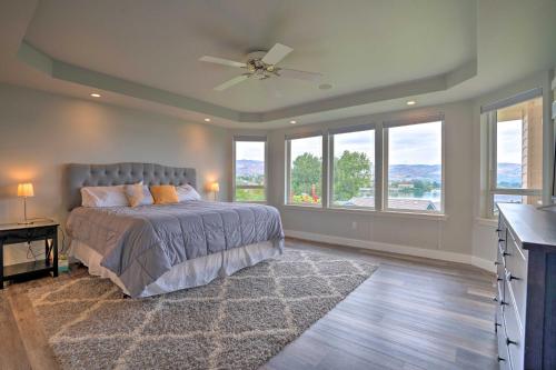 a bedroom with a bed with a ceiling fan and windows at Manson Villa with Hot Tub about 1 Mi to Wineries! in Manson