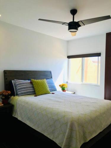 a bedroom with a bed with a ceiling fan at Adorable Casita w/Estuary & Ocean Views in Ensenada