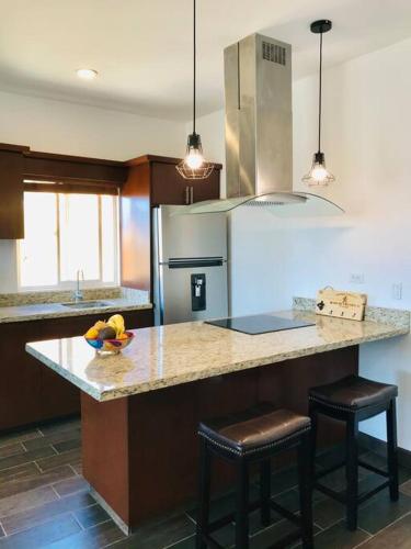 a kitchen with a island with two bar stools at Adorable Casita w/Estuary & Ocean Views in Ensenada