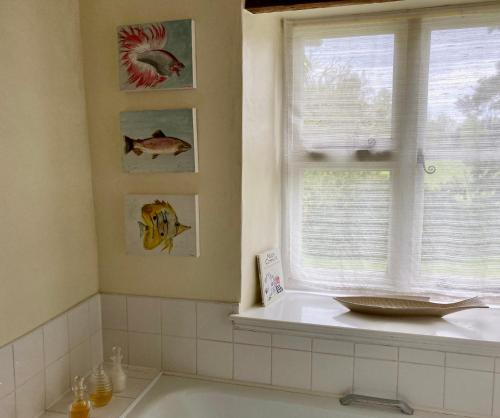 a bathroom with a bath tub and a window at Grange Farm in Thetford