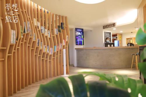 a lobby with a wall of wooden books at Dream 12 Hotel in Taichung