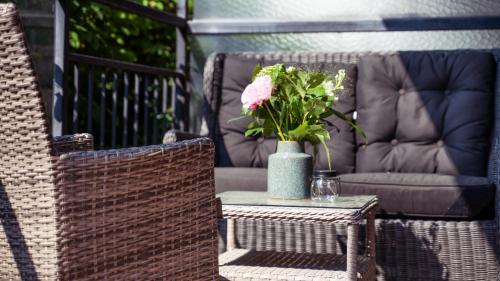 a vase with a pink flower sitting on a table at Home Hotel Carlscrona in Karlskrona