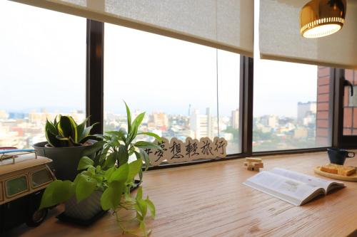 a room with a window with plants and a book at Dream 12 Hotel in Taichung