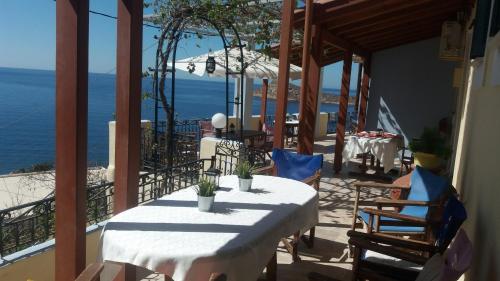 a table and chairs on a balcony with the ocean at Melina's Sunset in Myrties