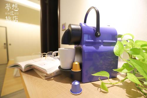 a blue coffee machine sitting on a desk with a book at Dream 12 Hotel in Taichung