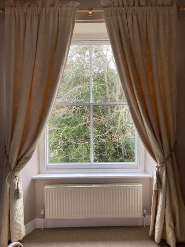 a window with curtains and a radiator in a room at Grange Farm in Thetford