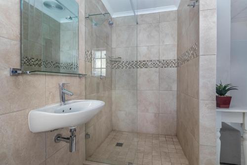 a bathroom with a sink and a shower at Anoud Manor in Hout Bay