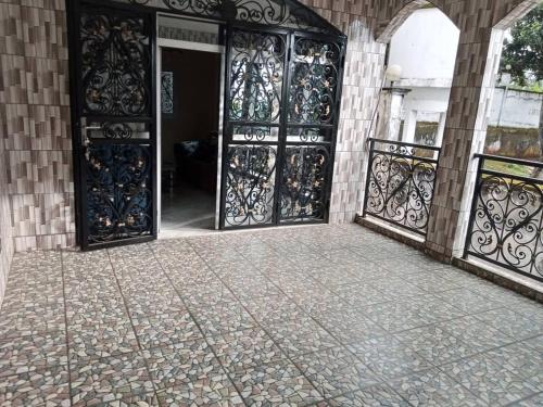 an open door of a building with wrought iron gates at RESIDENCE DU PELERIN - Villa l'écrin de verdure à Bandjoun in Bandjoun