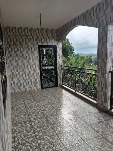 a room with a balcony with an open door at RESIDENCE DU PELERIN - Villa l'écrin de verdure à Bandjoun in Bandjoun
