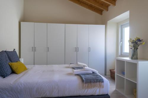1 dormitorio con 1 cama grande y armarios blancos en Cantinho dos Artistas, en Caldas da Rainha