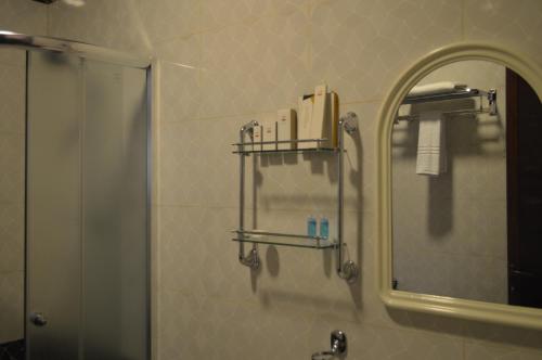 a bathroom with a mirror and a shower and a sink at Drwazet Nakheel Tourist Village in Al Hofuf