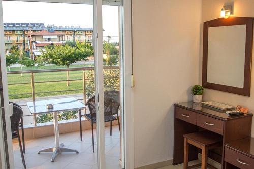 Pokój z biurkiem, lustrem i balkonem. w obiekcie Denis Studios and Apartments w Paralii Katerinis
